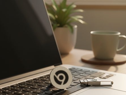 노트북 키보드 위에 놓인 크롬 로고가 새겨진 금속 배지와 USB 메모리