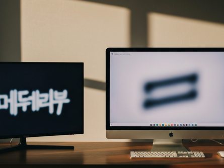 밝은 거실 소파에 놓인 노트북과 무선 마우스, 화면에 방송 재생 화면이 보이는 모습